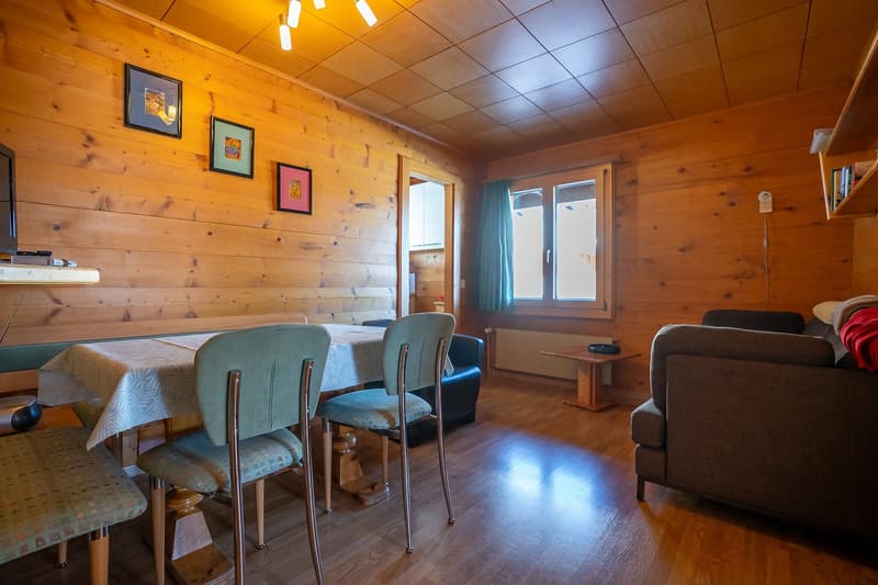 Dining room with a large table, chairs, a couch, and wooden decor