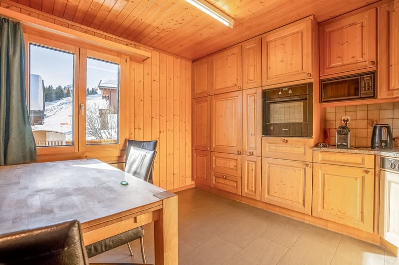kitchen with wooden cabinet, microwave, electric oven, countertop, dining table, window with curtain