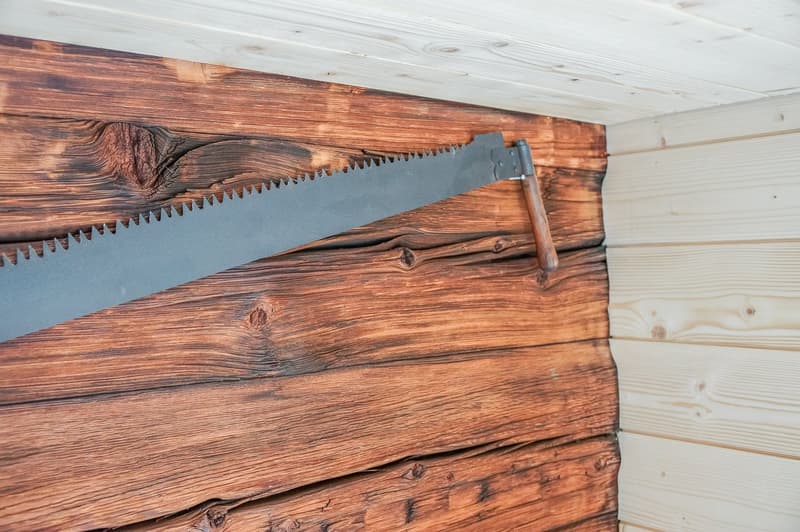 close-up of a saw hanging on wooden wall