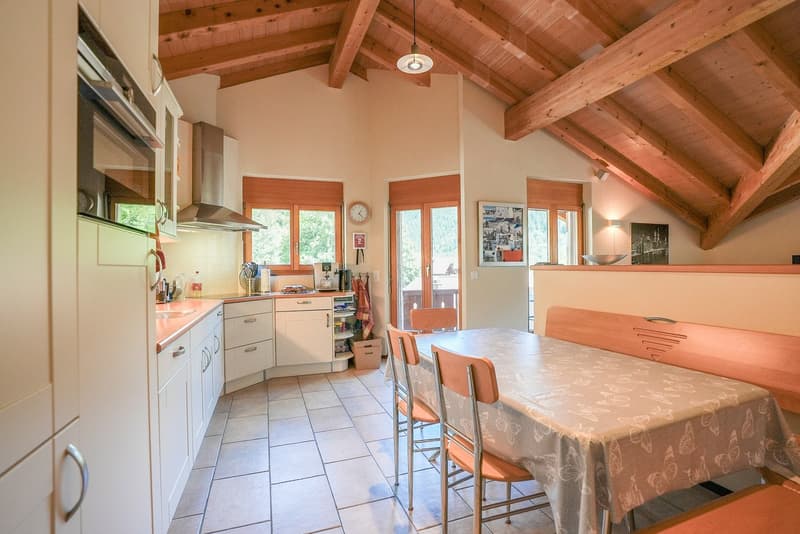 white cabinets, wooden countertop, dining table with chairs, open shelving, microwave, clock, kettle, basket, dining bench
