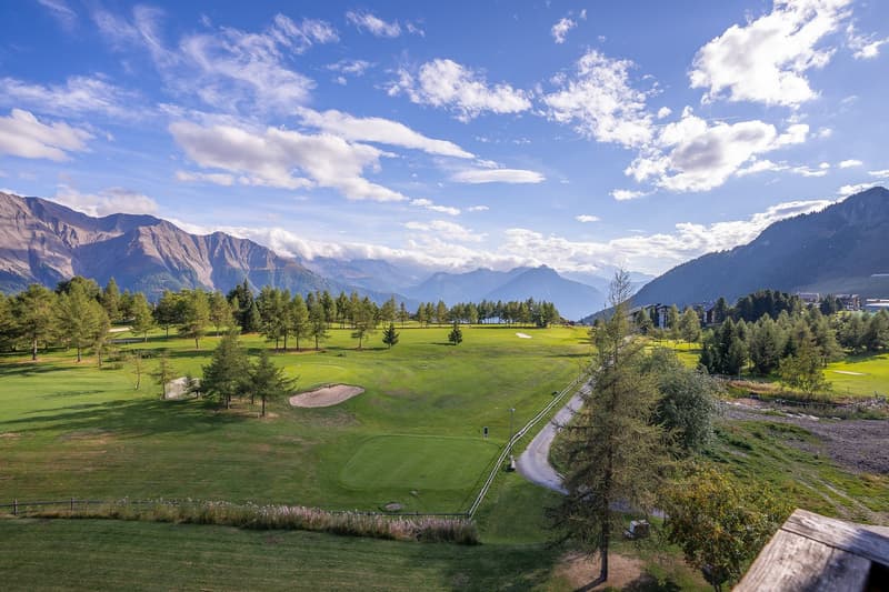 green golf course, trees, mountains, sunny day