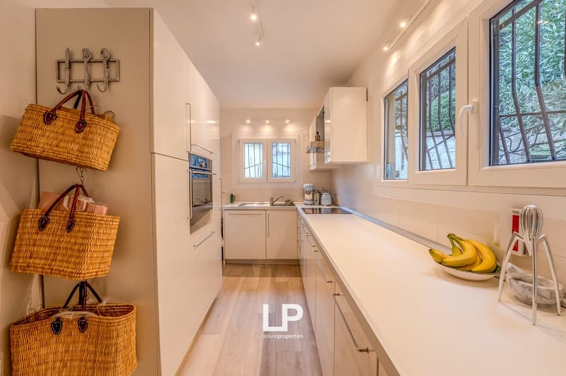 white cabinets, stainless steel appliances, kitchen island, large windows, natural light