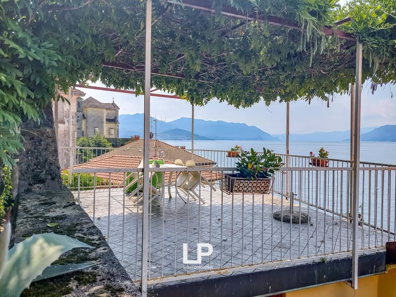 A terrace with a dining area, overlooking the water and mountains