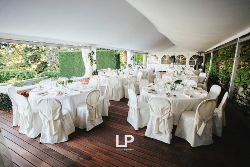 White canopy, wooden deck, white tents, covered tables, outdoor event setup