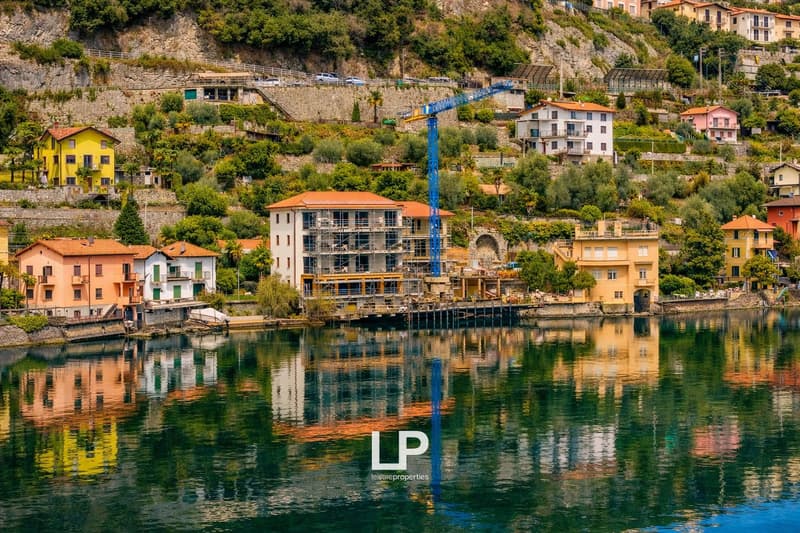 row of houses on the slope, near the water, under construction building, crane