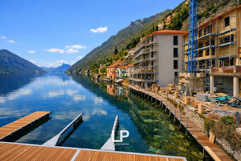 Lakefront scene with mountains in the background, wooden dock, boats, under construction buildings