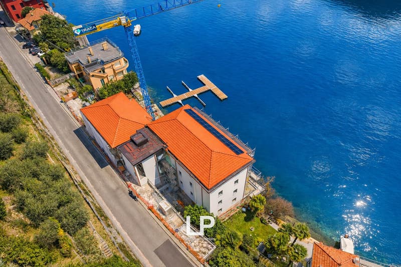 two buildings on the water's edge, large blue ocean, orange roofs, solar panels on the roof