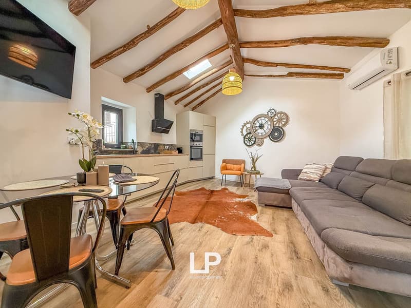 wooden floor, rustic wooden ceiling beams, dining table, chairs, sofa, kitchen, TV, air conditioner