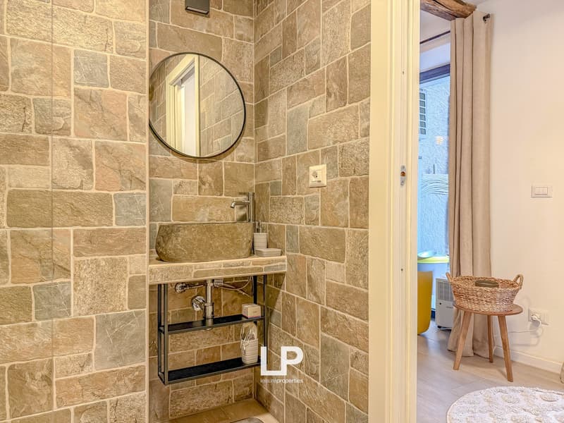 Stone wall, round mirror, sink, shower room, washing machine