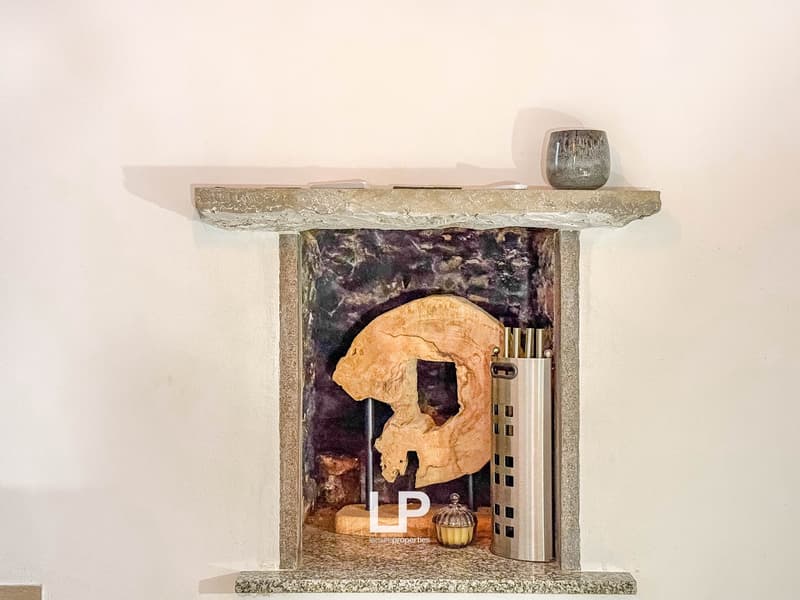 Fireplace with a sculpture, decorative items, and a candle holder on the mantel