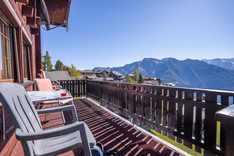wooden floor, fence, lounge chairs, table, mountain view