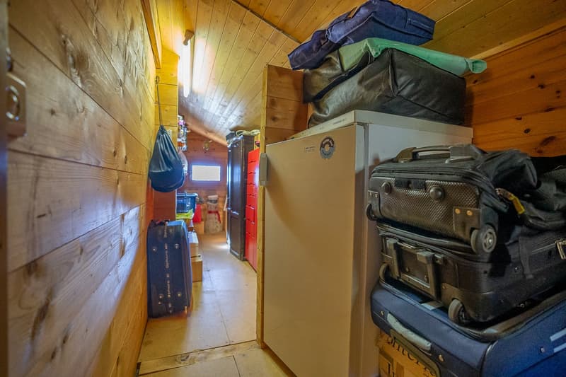 narrow storage room, luggage, bags, refrigerator, wooden walls