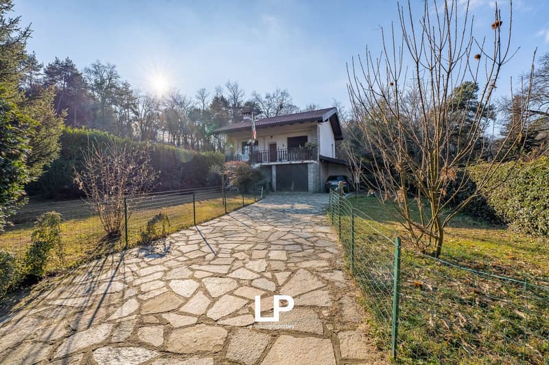 Detached house, stone pathway, garage, balcony, fenced garden, trees, view of the sky