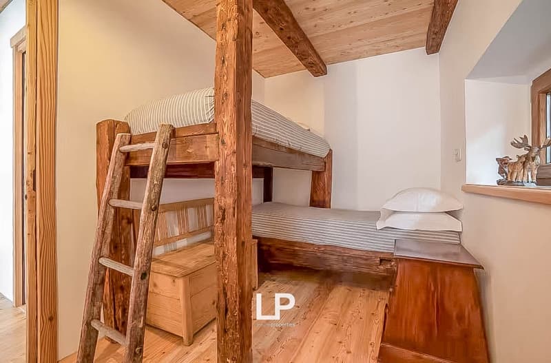 Double bunk bed with ladder, wooden storage box, and desk