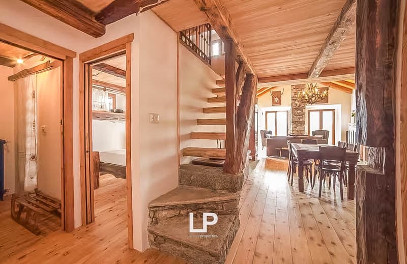 open floor plan, stone staircase, wooden beams, wooden floors, dining table and chairs