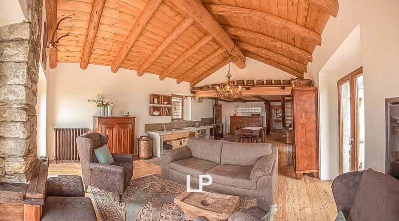 wooden ceiling, fireplace, wooden floor, large couch, armchair, center table, chandelier