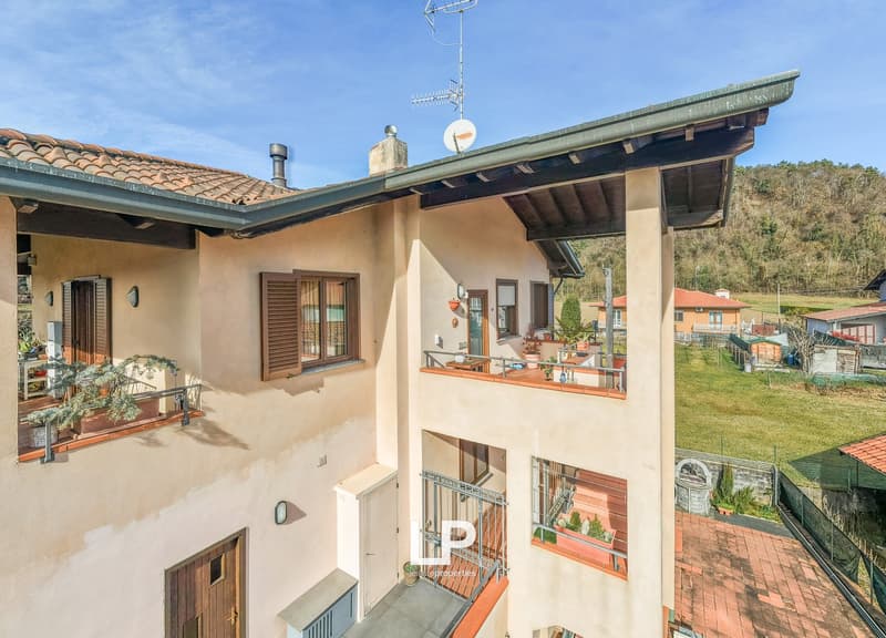 a 2 story house, wooden terrace, tile roof, chimney, satellite dish, multiple windows, entrance door, satellite dish
