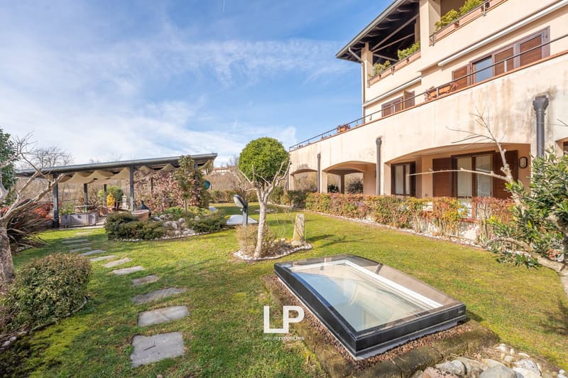 Gravel pathways, manicured lawn, hedges, small trees, shrubs, pergola, building terrace