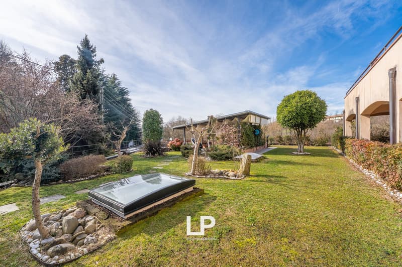large grassy area, walkway, small garden shed, glass roof