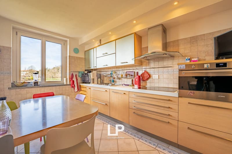 kitchen, wooden cabinets, modern appliances, dining table, chairs, large window, balcony