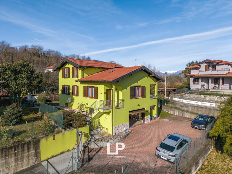 2 story house, yellow exterior, red roof, driveway, fenced area, 2 cars parked