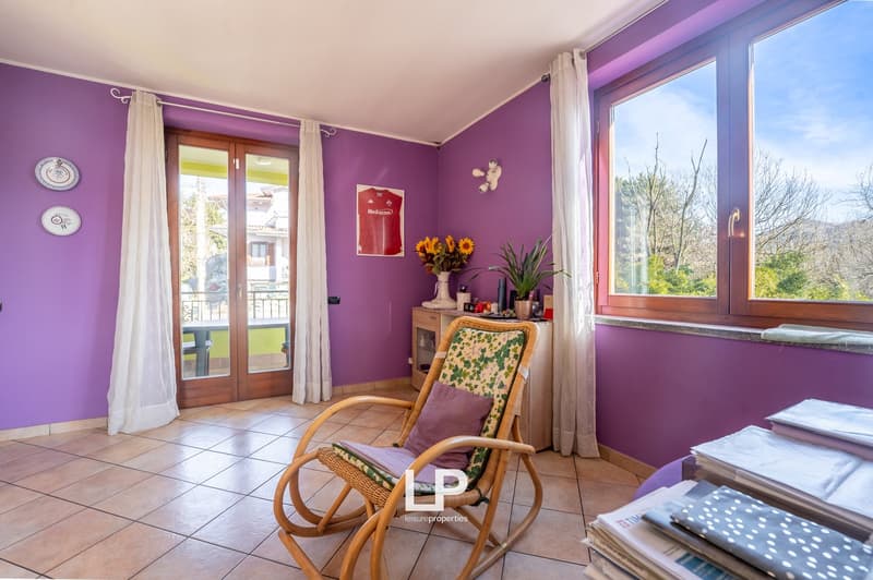 purple walls, wooden chair, table, window with balcony, potted plant, framed picture