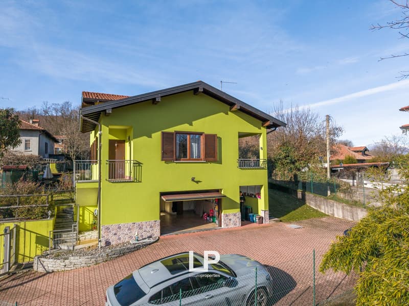 2 story house, yellow exterior, garage, balcony, car parked