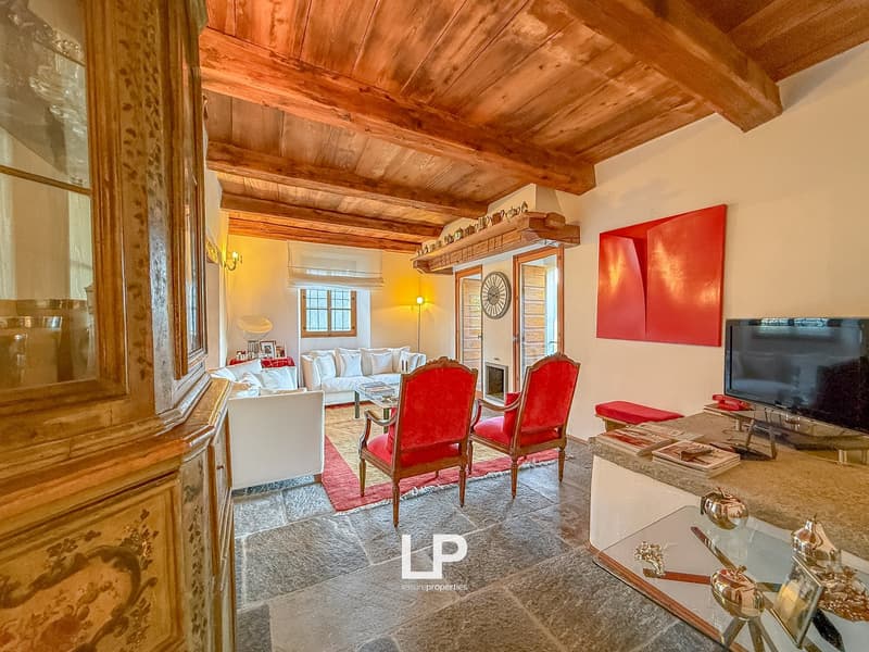 exposed wooden beams, living room, red armchairs, TV, rug, white sofa, fireplace