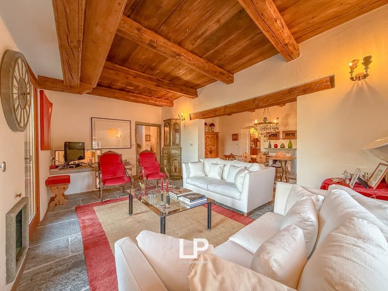 white sofa, glass coffee table, red carpet, wood beams, red armchairs, monitor, fireplace