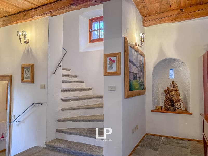 narrow staircase, arched alcove, picture frames, arched window, arched ceiling