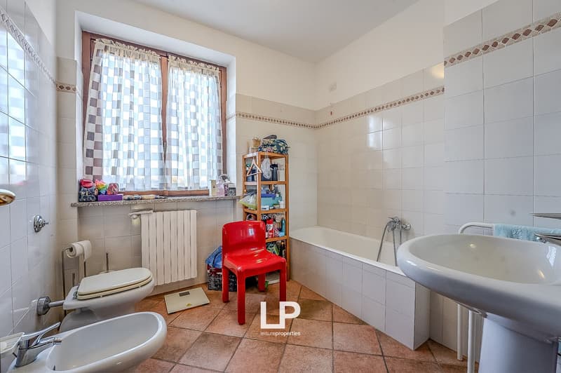 white tiles, bathtub, bidet, sink, radiator, toilet, window, towels