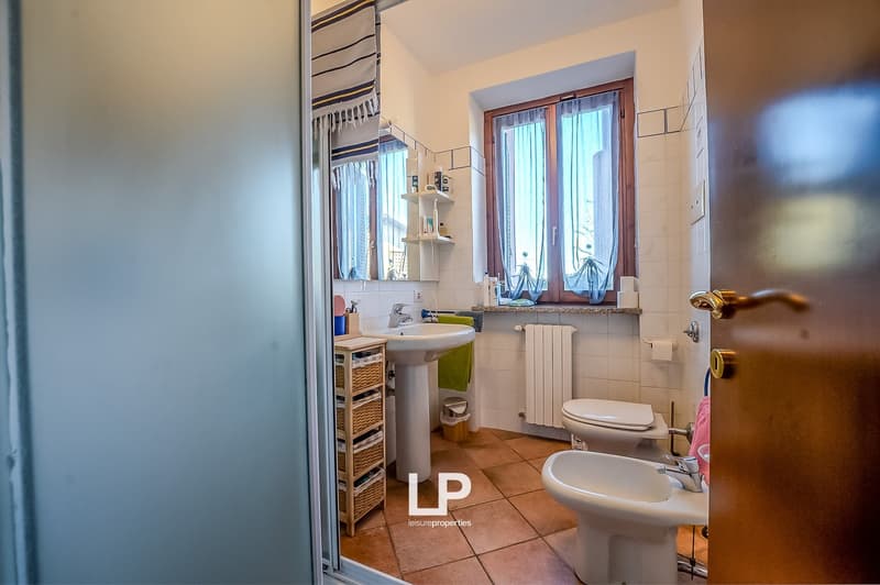 single sink, shower, toilet, bidet, shelves, radiator, window