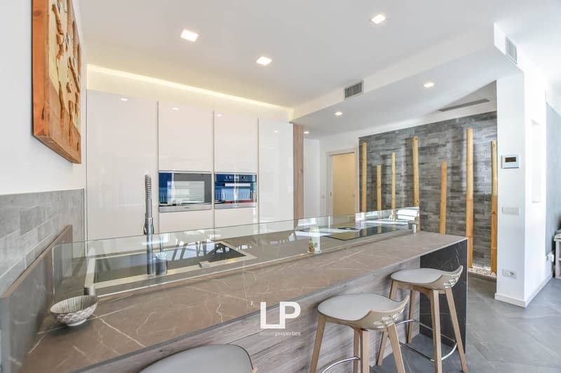 modern open plan kitchen, grey marble countertops, white cabinets, integrated appliances, breakfast bar with 3 bar stools