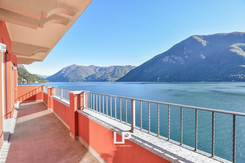 Terrace with tiled floor, metal railings, unobstructed view of lake and mountains