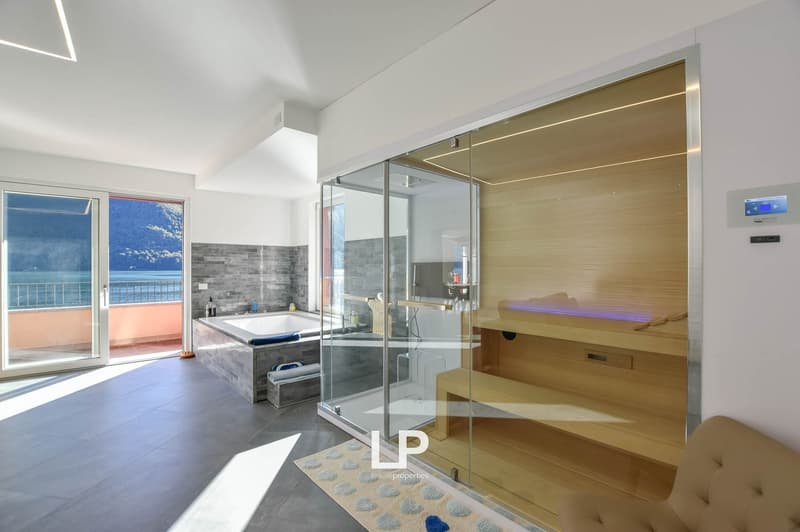 Modern bathroom with a glass door, bathtub, separate shower, sauna, and glass door to balcony