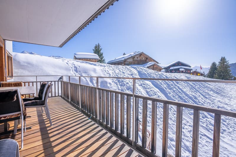 wooden deck, metal railing, chairs, table, snowy mountain view