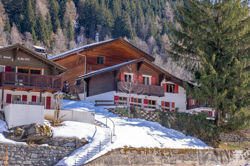 wooden exterior, red shutters, snow-covered ground, balcony, mountain view