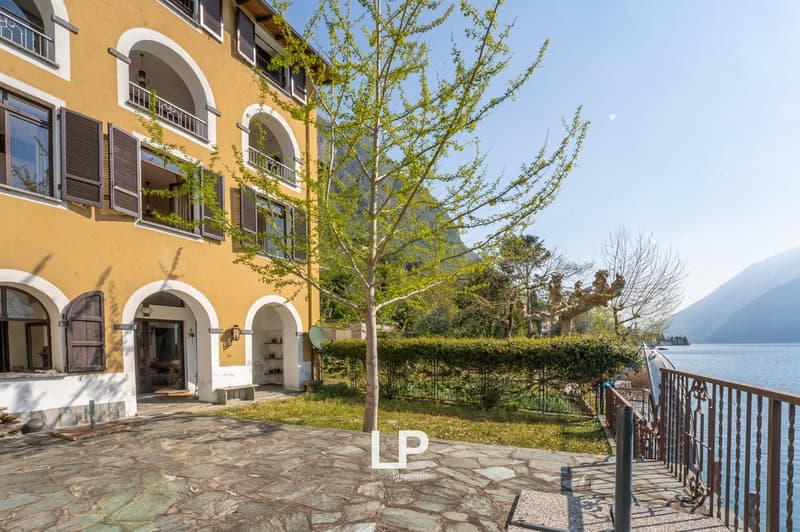 yellow building, arched windows, balcony, stone pathway, lake view