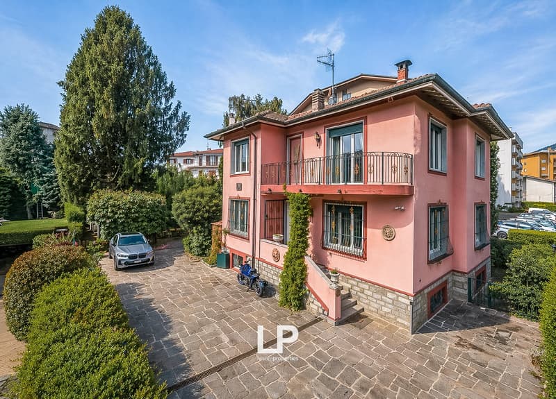 2 story house, pink exterior, brick ground floor, balcony, parking place, garden, trees