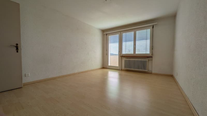 empty room, wooden floor, white walls, sliding glass door, window with blinds, power outlet, radiator