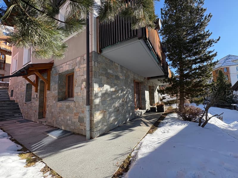 Stone walls, balcony, covered entrance, snow on ground, trees
