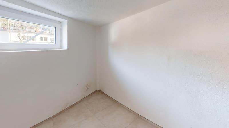 white walls, tile floor, small window, power outlet
