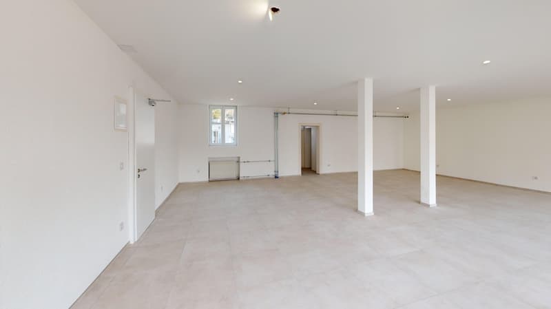 empty room with white tiled floor, ceiling with white ceiling lights, white walls, window with glass, door on the left