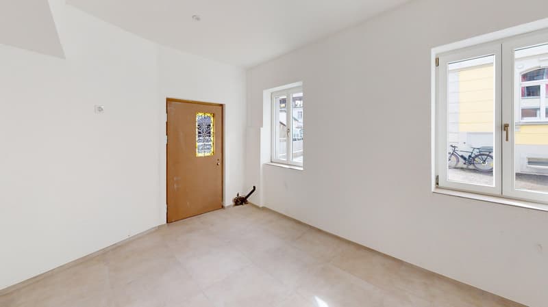 empty room, white walls, tiled floor, two windows, and a door