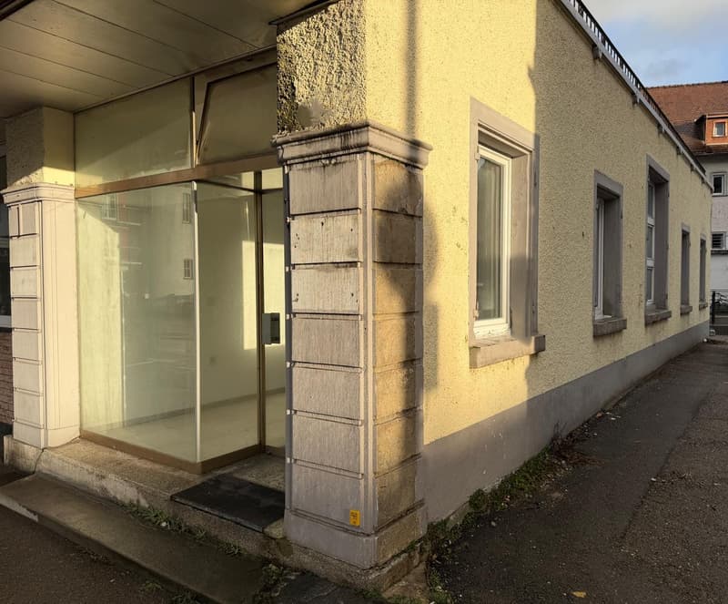 Single house, elevated ground floor, yellow painted, glass windows, glass entrance door
