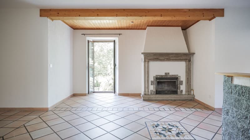 white walls, tiled floor, large open door, fireplace against a wall