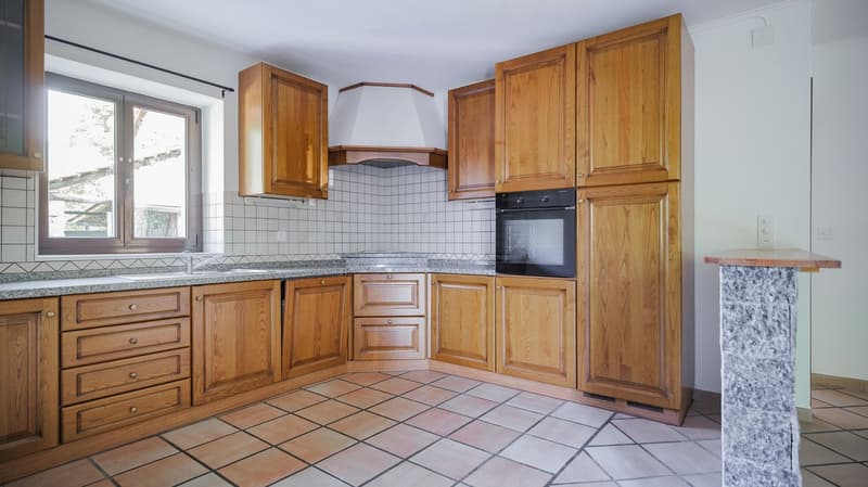 wooden cabinets, granite countertop, integrated sink, modern oven, natural light from window