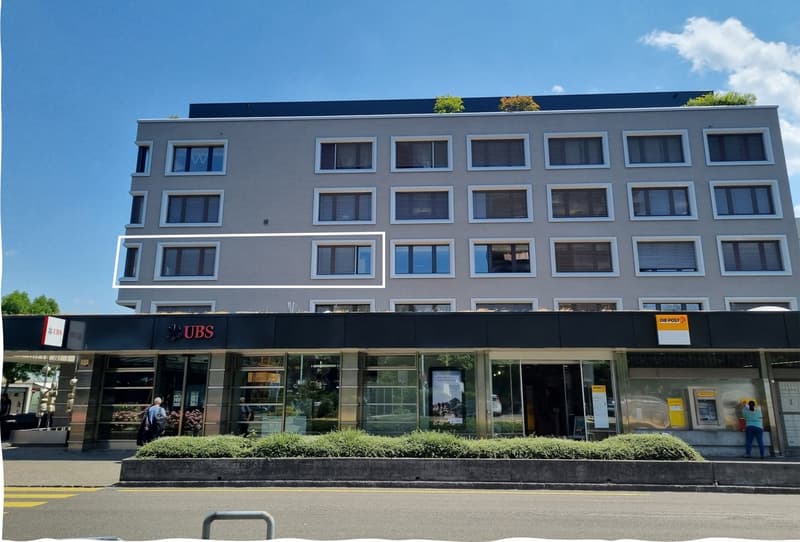 Apartments, grey facade, multiple windows, banking branch