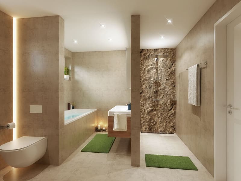 modern bathroom with grey tiles, walk-in shower with stone wall, bathtub, wooden countertops, green rugs, two candle holders, white towels, plant in corner