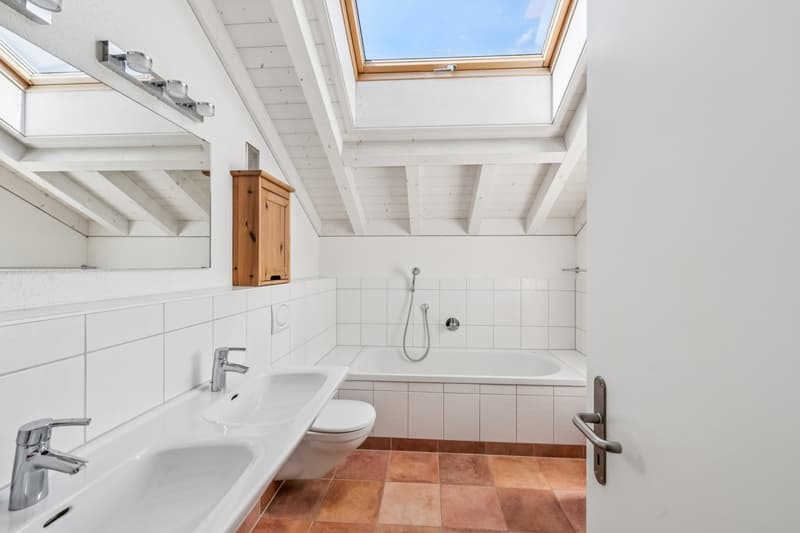 Im Obergeschoss befindet sich ein helles Familienbad mit einer Badewanne sowie einer Dusche